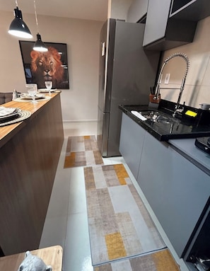 Enjoy meals in this kitchen with a stainless steel refrigerator, sink, and dining area.