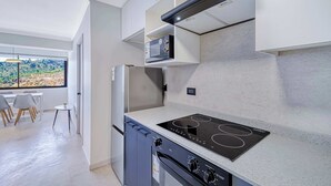 A modern kitchen with a built-in oven, a stove, and a refrigerator.