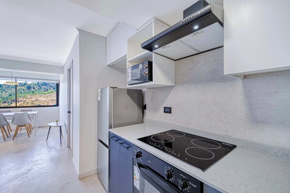 Una cocina moderna con horno empotrado, estufa y refrigerador.