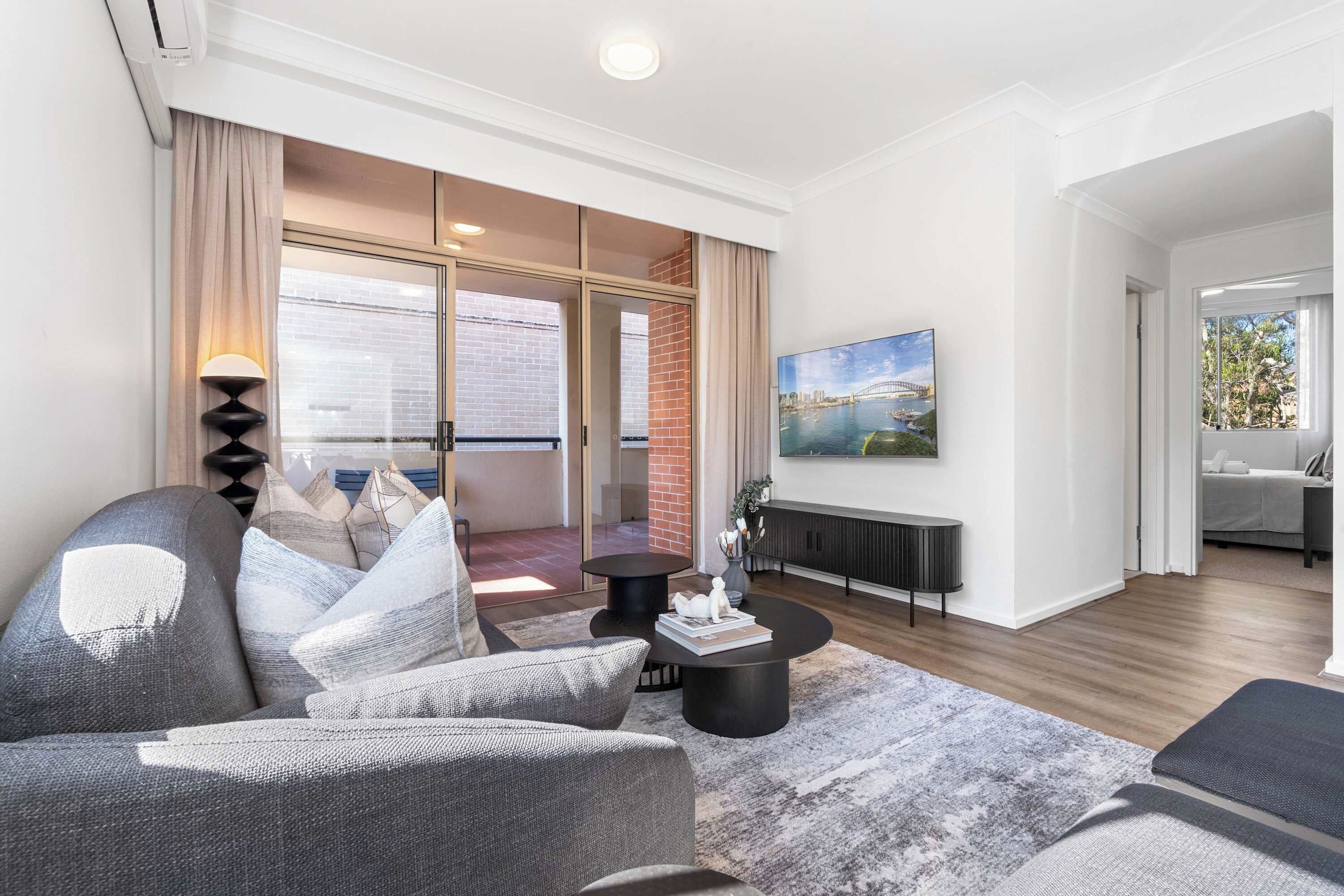 A modern living room with a sofa, coffee table, and a painting on the wall.