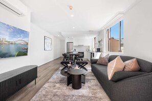 A modern living room with a sofa, coffee table, and artwork. - Camperdown Cozy Corner 6 (Camperdown)