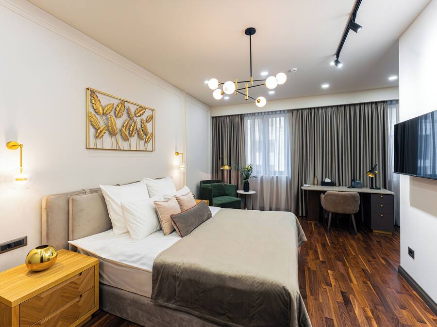 Une chambre d’hôtel moderne, dotée d’un grand lit, d’un bureau et d’une télévision.