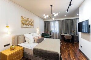 Ein modernes Hotelzimmer mit einem großen Bett, einem Schreibtisch und einem Fernseher.