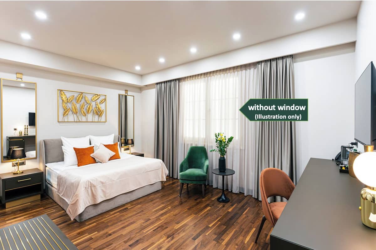 Ein modernes Hotelzimmer mit Bett, Schreibtisch, Stuhl und Fernseher.