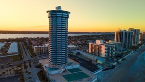 A high-rise hotel with a cylindrical design, located near a beach with a view of the ocean. - The Serenity at Peck Plaza (Daytona Beach)