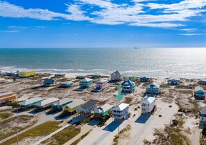 A coastal residential area with beachfront properties, some elevated on stilts, and a clear view of the ocean. - Fort Morgan | Gulf and Bay Views | Beach Access (Gulf Shores)