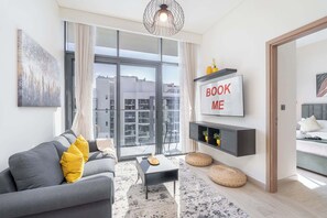 Un salon moderne avec un canapé, une table basse et un téléviseur fixé au mur.