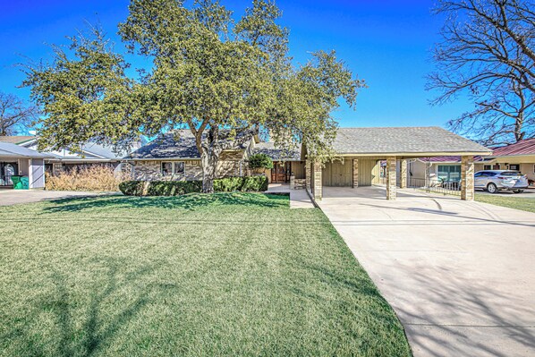 Situated in a quiet suburban neighborhood, this traditional home offers a shaded porch and a well-manicured lawn.