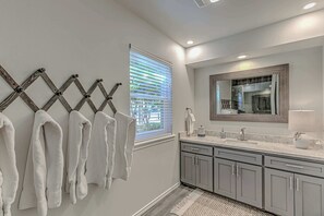 Bathroom features a large mirror, sink, and grey cabinets.