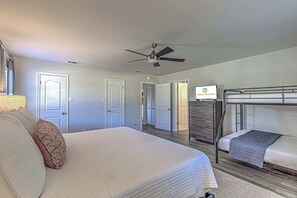 Relax in this spacious room with a large bed, bunk bed, and TV on a dresser.