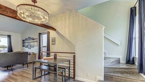 A spacious living area with a dining table, a sofa, and a staircase leading to an upper level. - Cozy 3 BDR Condo in Horseshoe Bay, Near Marina! (Horseshoe Bay)