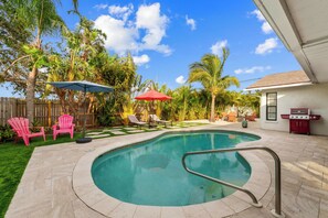 A backyard with a swimming pool, patio furniture, and a barbecue grill. - Heated Pool ,Mini Golf, Game Room, Near Beaches (Bradenton)