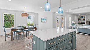 A kitchen with a large island, pendant lights, and a dining area with chairs and a table. - ☀️Charming 30A Home with Private Pool-Short Walk to Beach-Jini Jim Jams☀️ (Santa Rosa Beach)