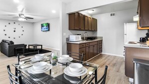 A modern kitchen with wooden cabinets, a microwave, and a sink.