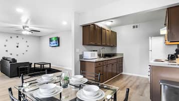 A modern kitchen with wooden cabinets, a microwave, and a sink.