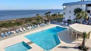 Une piscine avec des chaises longues et vue sur l’océan.