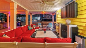 A cozy lounge area with a red sofa, white coffee table, and a ceiling fan. - A Little Piece Of Heaven-5BR-2nd Row-Pet Friendly (North Myrtle Beach)