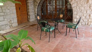 A patio with stone walls, a wooden door, and a table with chairs. - Detached south-facing studio with swimming pool, property overlooking Toulon harbour  (Toulon)