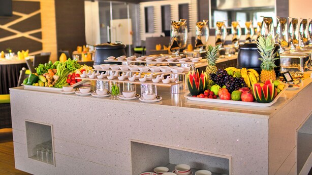 A buffet area with a variety of fruits, vegetables, and beverages.
