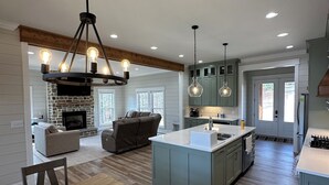 A spacious kitchen with a central island, wooden flooring, and pendant lighting. - Stunning 4-bedroom house with amazing outdoor space and dock in Double Springs. (Double Springs)