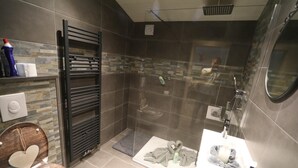 A modern bathroom with a shower, toilet, and sink. - Apartment Haus Tauern Am See  (Heiterwang)