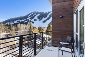 Un balcón con vista a una montaña nevada y un edificio de madera.