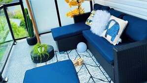 A balcony with a blue sofa, a small table, and a potted plant. - Spacious 3Story,3bedroom,Pets Park,Near UofA&more attractions.Luxury starts here (Edmonton)