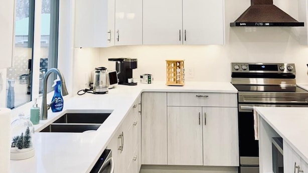 A modern kitchen with white cabinets, stainless steel appliances, and a central island. - Spacious 3Story,3bedroom,Pets Park,Near UofA&more attractions.Luxury starts here (Edmonton)
