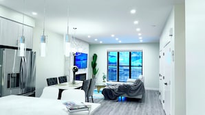 A modern kitchen with a dining area, a TV mounted on the wall, and a large window with a view. - Spacious 3Story,3bedroom,Pets Park,Near UofA&more attractions.Luxury starts here (Edmonton)