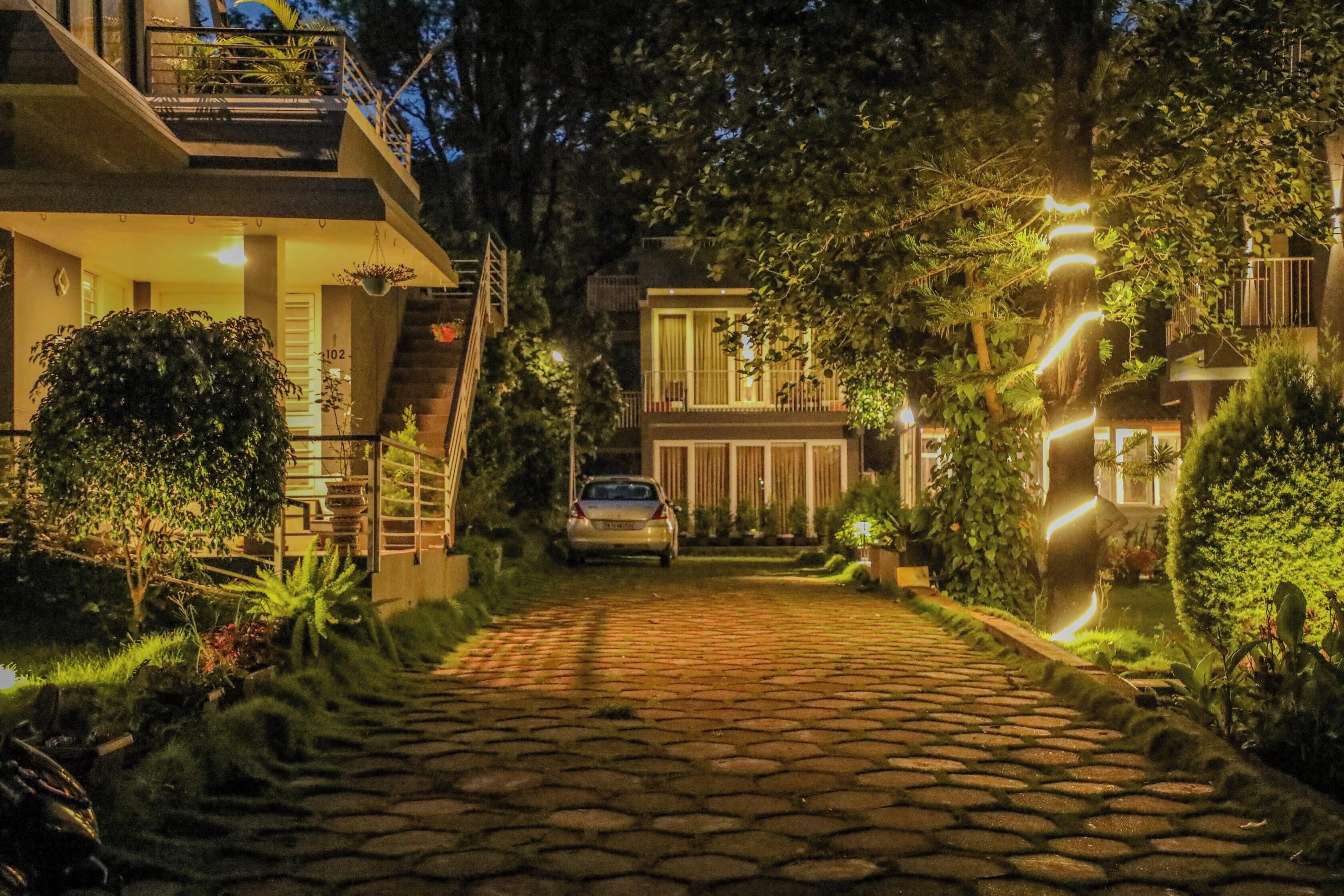 A paved driveway leading to a building with a car parked in front.