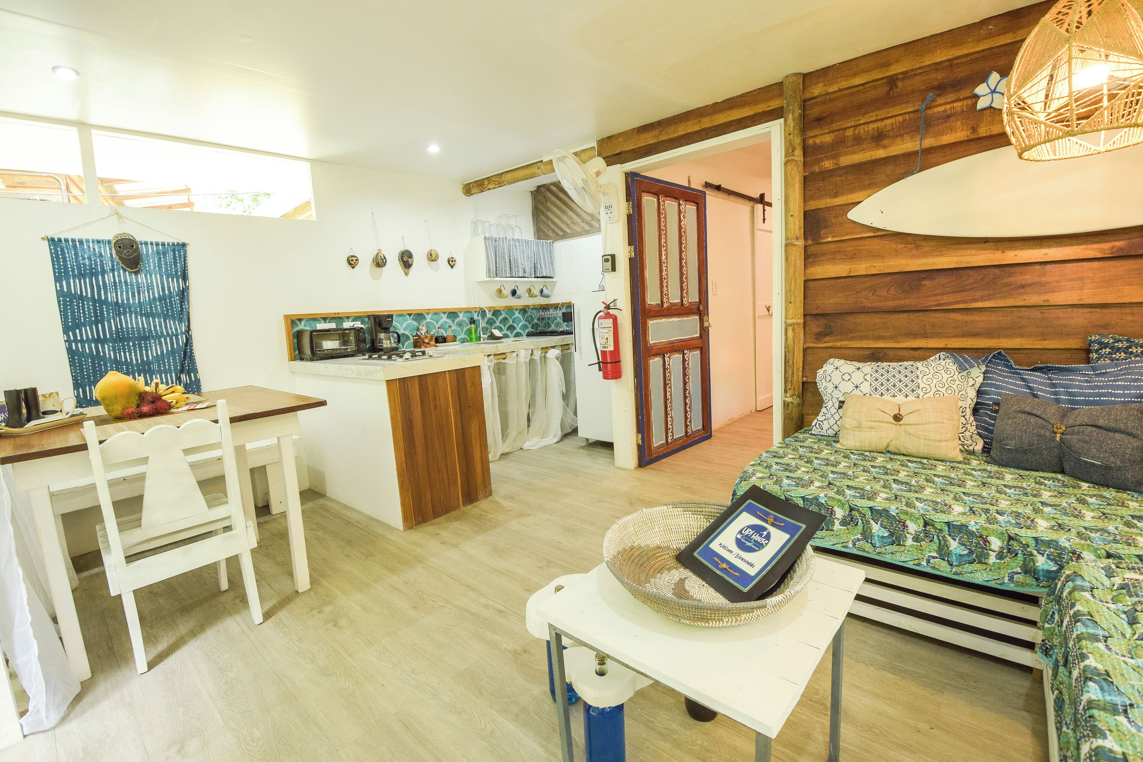 A compact living space with a kitchenette, a dining area, and a bedroom.