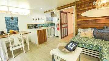 A compact living space with a kitchenette, a dining area, and a bedroom.