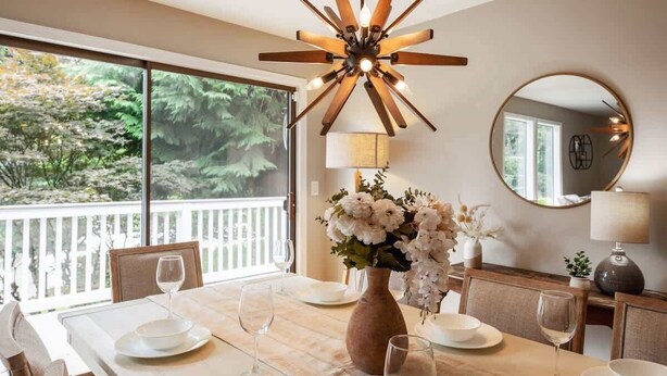 A dining area with a large table set for six, a vase of flowers, and a modern ceiling light. - Serene 3b2b Home, Family-Friendly, Backyard & A/C (Redmond)