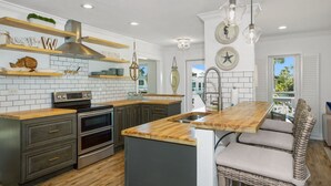 A modern kitchen with a central island, built-in ovens, and a large window. - 🌊Private Pool-Great for Large Groups-6BR Coral Cove🌊 (Fort Myers Beach)