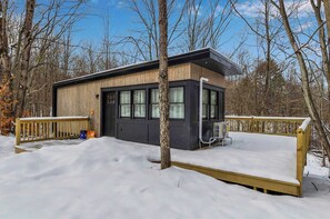 Eine Holzhütte mit großen Fenstern und einer Terrasse.