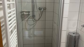 Een douche, handdoeken, zeep, toiletpapier