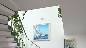 A staircase with green steps and a wooden handrail, leading to a landing with a painting of a sailboat. - Villa historic center sea view (Anzio)