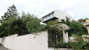 A modern house with a flat roof, a white exterior, and a covered entrance. - Villa historic center sea view (Anzio)