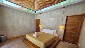 A modern bedroom with a large bed, wooden headboard, and a skylight. - Serenity Wave Bungalow (Cahuita)