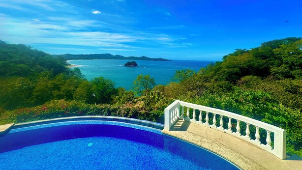 A swimming pool with a view of the sea and distant islands. - Romantic Getaway with Stunning Panoramic Ocean Views, Amazing Sunsets (Playa Flamingo)
