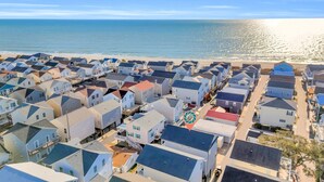 A coastal residential area with multiple houses, a beach, and a clear view of the ocean. - Spacious 5-bedroom house with a quick walk or golf cart ride to the beach (Myrtle Beach)