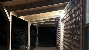 A covered wooden deck with a view of a building's exterior. - Center of Everything Southern Maine… 3-bedroom house, huge yard in Buxton (Buxton)