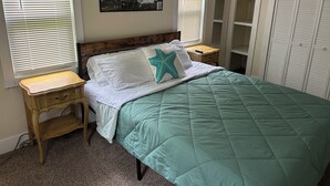 A bedroom with a bed, a nightstand, a wooden dresser, a painting on the wall, and a closet. - Center of Everything Southern Maine… 3-bedroom house, huge yard in Buxton (Buxton)