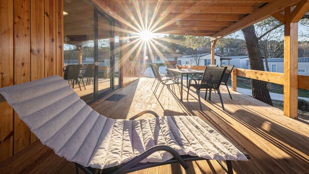 A wooden deck with a sun lounger, a table, and chairs. - Mobile House Magoro 5 (Benkovac)
