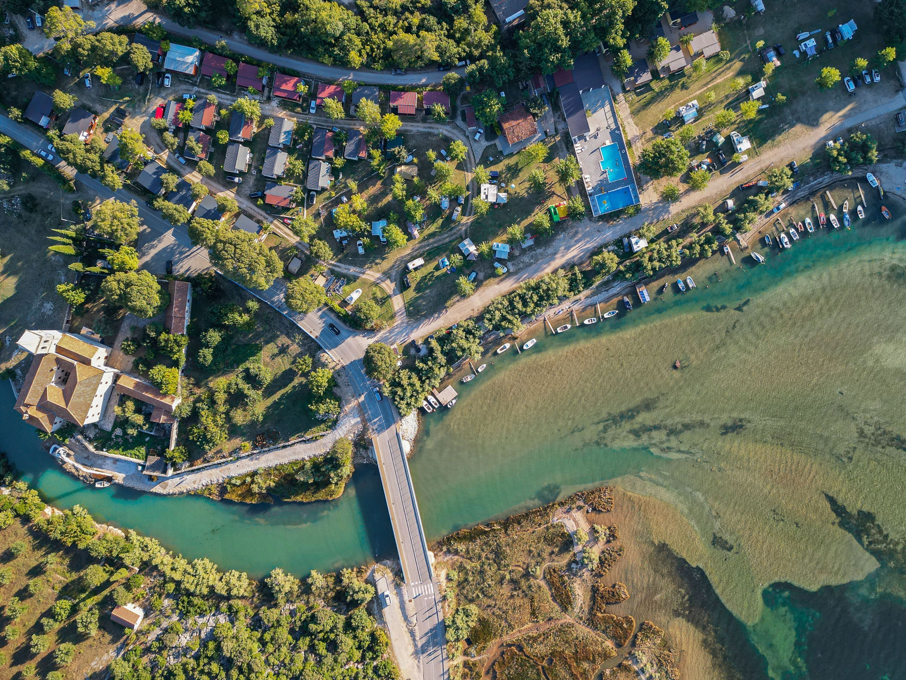 Vista aérea de una zona costera con casas, un puente y barcos.