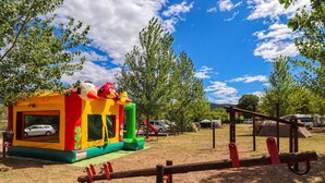 An outdoor playground with a bounce house, seesaw, and swings. - Mobile House Magoro 5 (Benkovac)