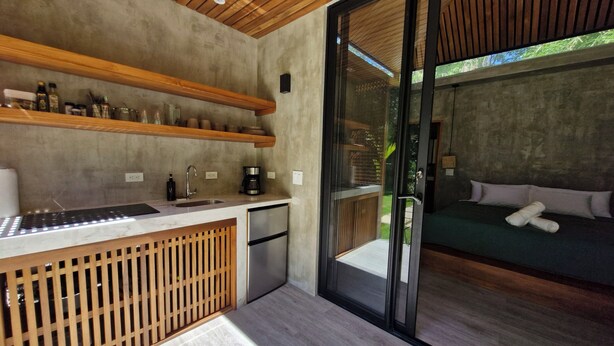 A modern kitchen with a wooden countertop, a built-in sink, and a coffee maker. - Serenity Sand Bungalow (Cahuita)