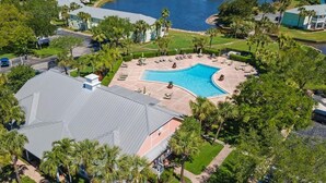 Eine Vogelperspektive eines Resorts mit Schwimmbad, Palmen und einem Wasserabschnitt.