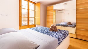A bedroom with a bed, a wardrobe, and a window with a view. - La Terrazza del Garraffello (Palermo)