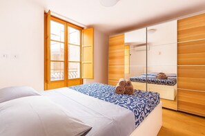 A bedroom with a bed, a wardrobe, and a window with a view. - La Terrazza del Garraffello (Palermo)